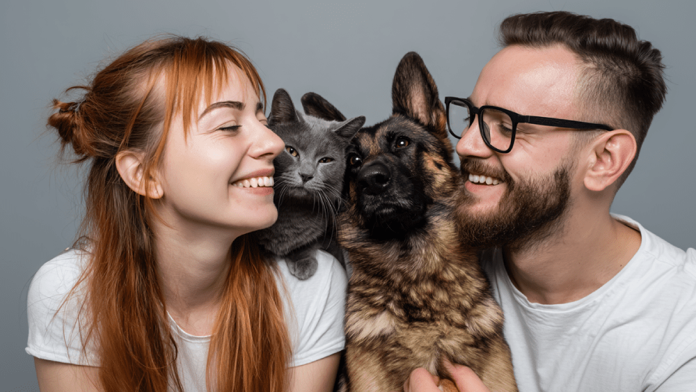 Man and woman kissing a dog