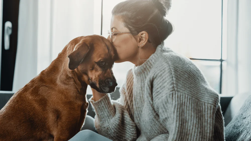 Woman kissing her dog 