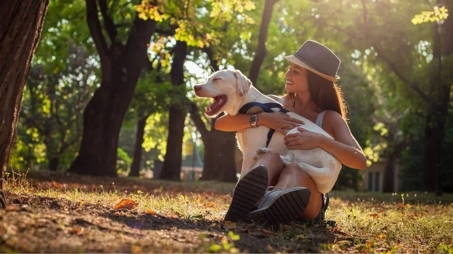 A woman hugging her dog at the park