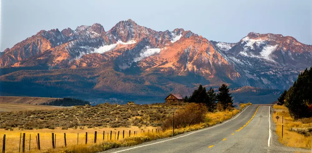 The Sawtooth mountains and a log cabin at sunrise.