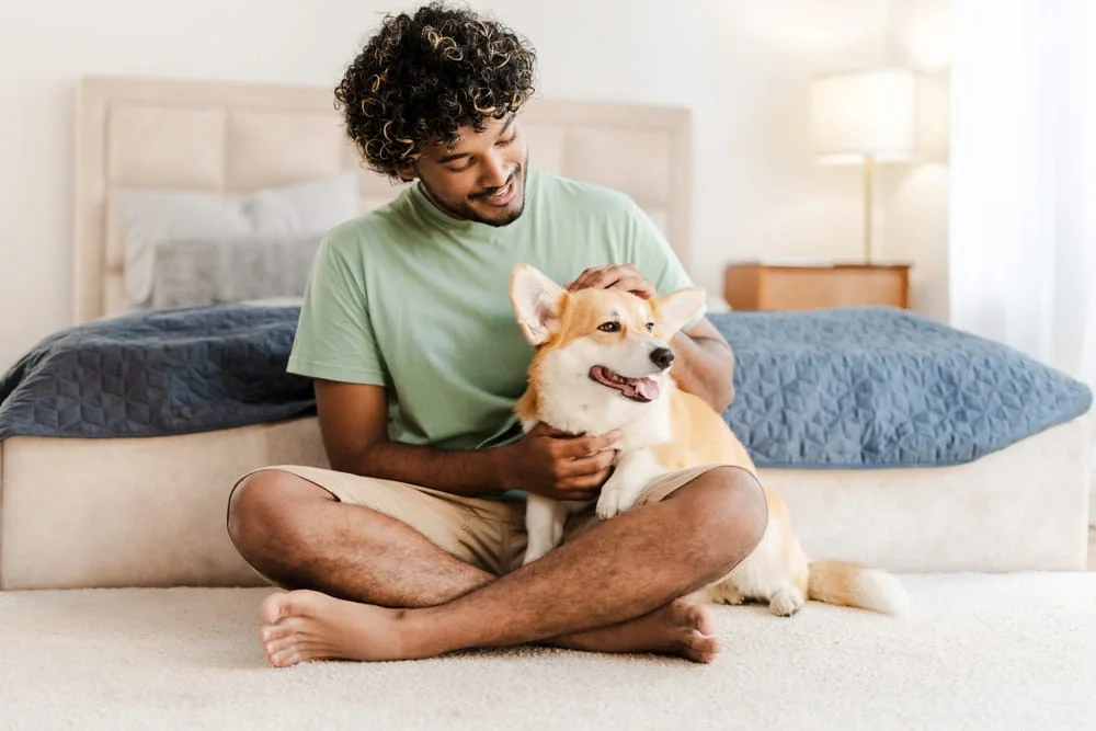 man sitting on the ground holding his dog