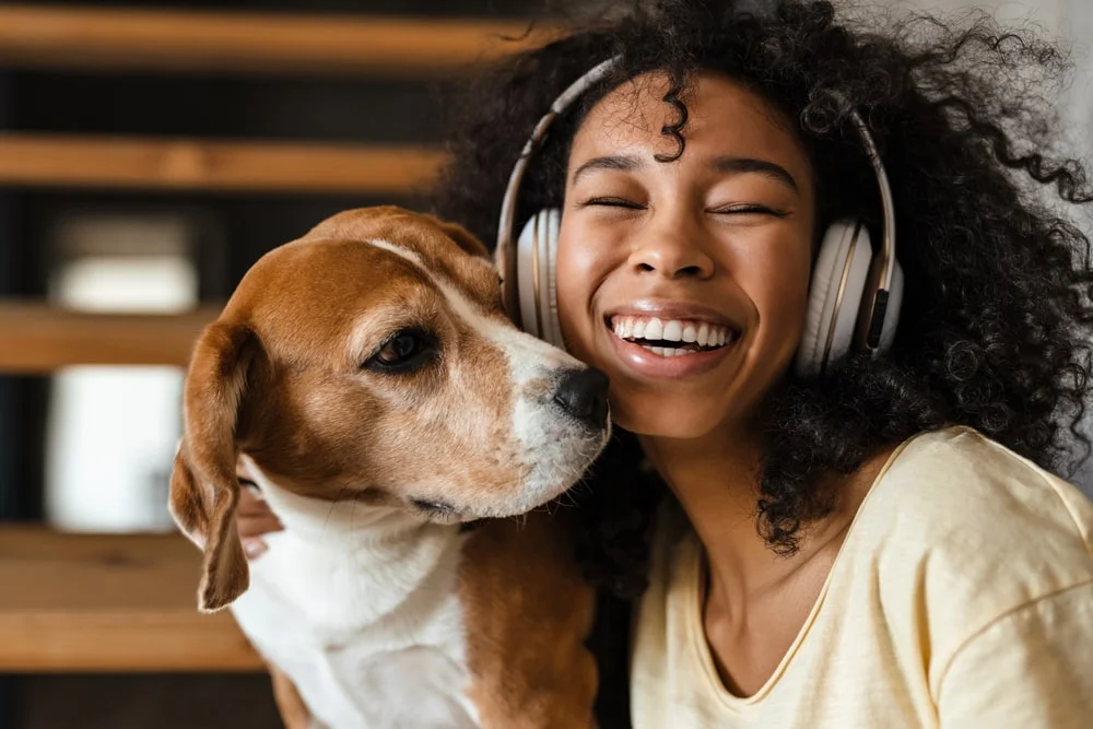 African american woman with headphones and her dog