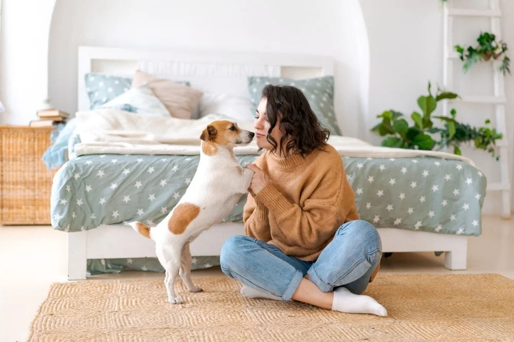 Woman giving her dog a kiss on the nose