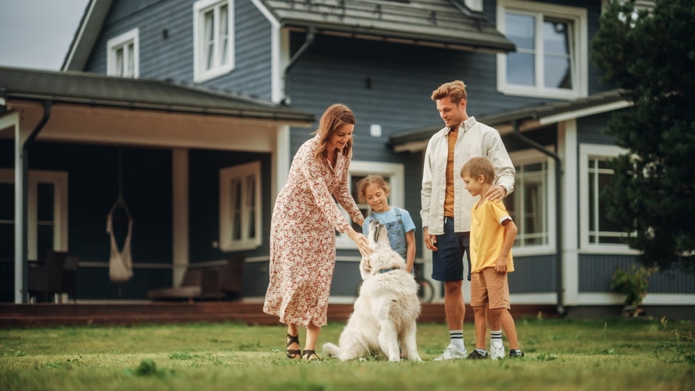 Family playing with a dog in their backyard