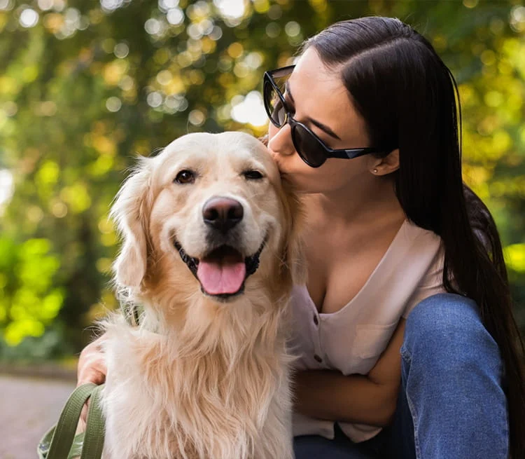 A woman kissing her dog on the head