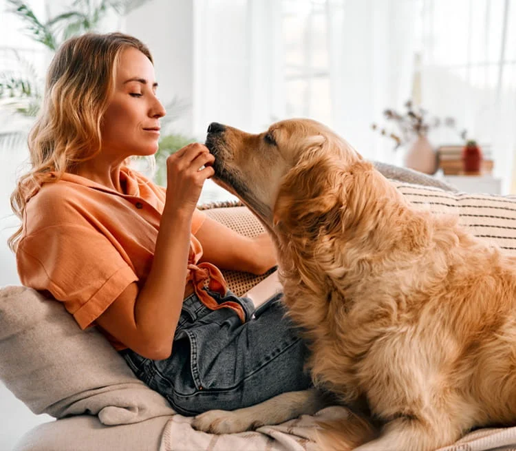 A woman giving a dog a treat