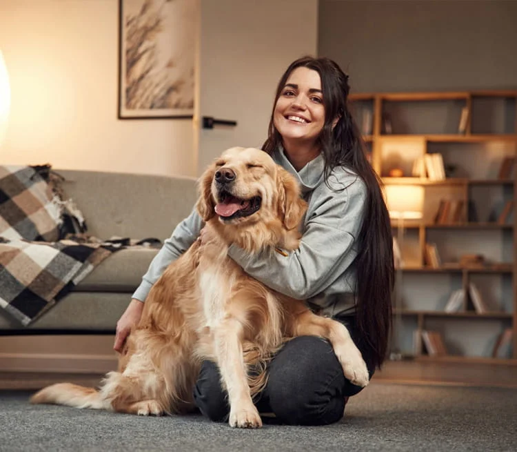 A woman cuddling with her dog on the floor